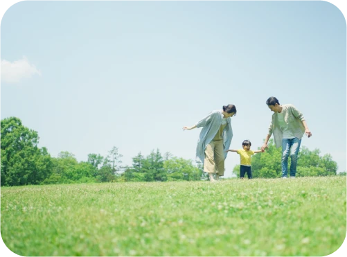 草原で楽しく遊ぶ家族の写真